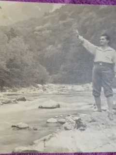 Fotografie, barbat in exursie la munte, pe malul unui parau, perioada interbelica