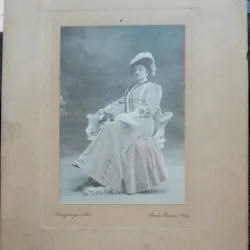 Fotografie pe carton, in tinuta de epoca, asezata pe un jilt, sfarsit de secol XIX