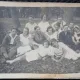 Fotografie tip Carte Postala, Grup de prieteni la iarba verde, perioada interbelica